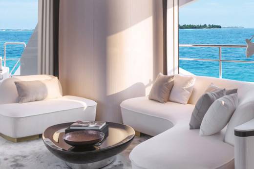 Relax in luxurious comfort on a yacht's plush seating, overlooking the stunning turquoise waters of a tropical paradise.