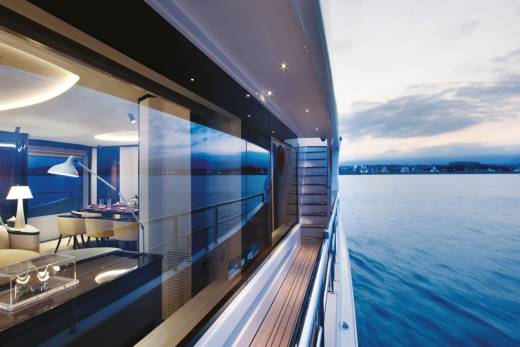 Modern yacht interiors blend seamlessly with the serene twilight waters of a coastal town.