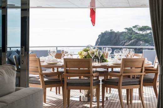 Dine al fresco on this luxurious yacht's deck, surrounded by stunning coastal views and elegant table settings.