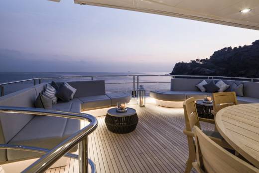 Relax on the deck of this luxurious yacht as the sun sets over the tranquil ocean.