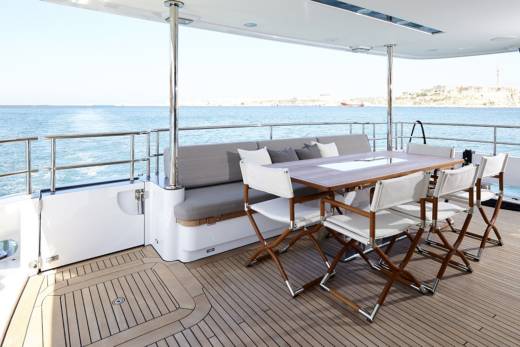 Enjoy al fresco dining with a stunning ocean view from the deck of this luxurious yacht.