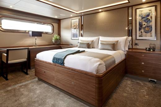Luxurious wood finishes and elegant artwork create a serene and sophisticated master suite on this opulent yacht.