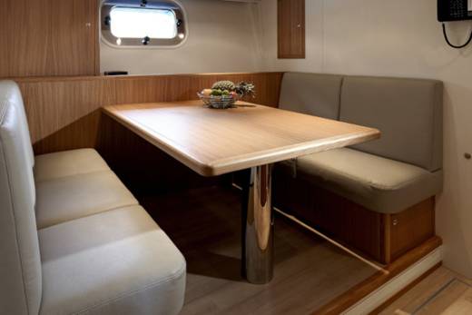 A cozy dinette with plush seating and a wooden table offers a comfortable spot to relax and dine onboard.
