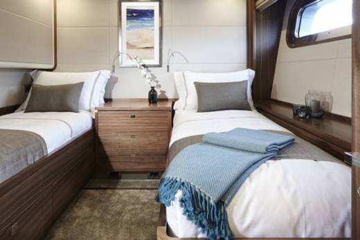 Two neatly made beds with plush throws await weary travelers in this cozy cabin.