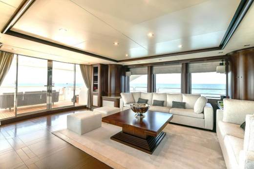 Luxurious yacht salon offers stunning ocean views through expansive windows and comfortable seating for relaxation.