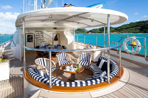 Relax on the luxurious deck of a yacht with stunning views of turquoise waters and lush green islands.