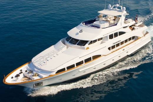 The luxurious yacht Enchantress glides through the deep blue ocean, leaving a foamy wake behind.