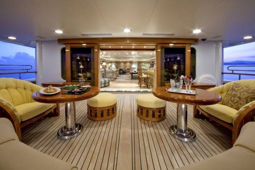Enjoy a luxurious evening on deck with champagne and sushi as the sun sets over the ocean.