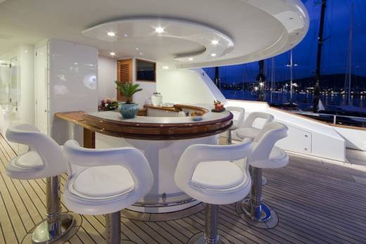 Enjoy cocktails at this elegant yacht bar overlooking a serene harbor at dusk.
