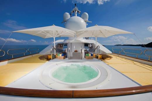 Relax in the bubbling hot tub on the deck of this luxurious yacht, surrounded by the sparkling blue ocean.