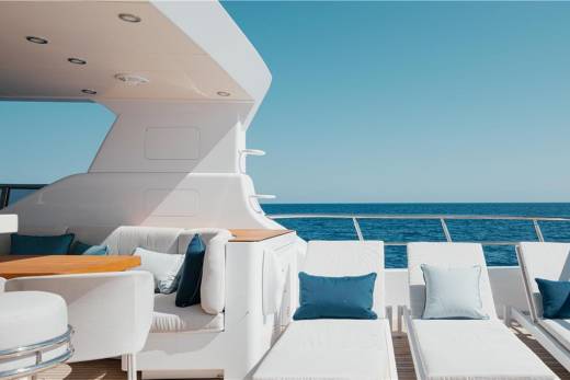 Relax on the luxurious deck of a yacht, surrounded by plush seating and the endless blue ocean.