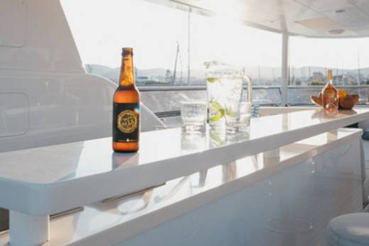 Enjoy a refreshing drink on the deck of a luxury yacht as the sun sets over the horizon.
