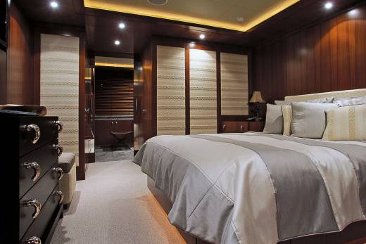 Luxurious wood paneling and plush bedding create a serene and elegant master suite aboard this yacht.