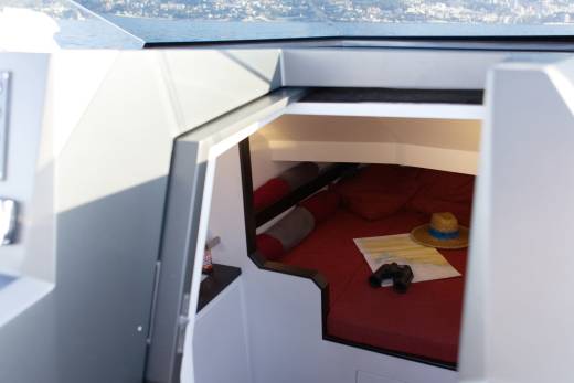 A cozy cabin on a boat offers a comfortable place to rest with a map, binoculars, and hat ready for adventure.