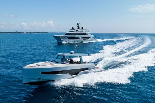 Two sleek yachts cut through the azure waters under a clear blue sky.