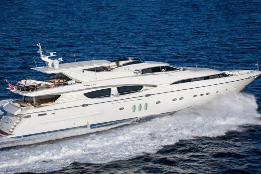 A sleek white yacht cuts through the deep blue ocean, leaving a powerful wake in its path.