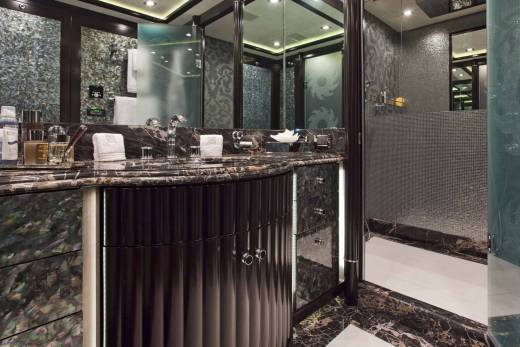 Luxurious dark wood cabinetry and marble countertops create an opulent vanity area in this sophisticated yacht bathroom.
