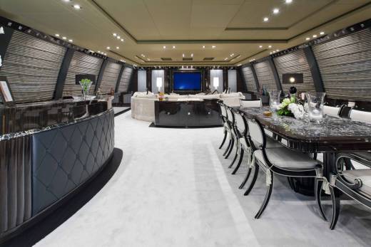 Luxurious yacht interiors feature a sleek bar, elegant dining area, and a spacious lounge with a large screen television.