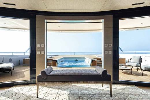 Luxurious yacht interiors seamlessly blend with the ocean view, featuring a plush daybed overlooking a serene infinity pool.