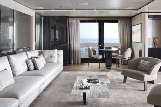 A luxurious yacht salon offers a serene seating area with ocean views and elegant marble accents.