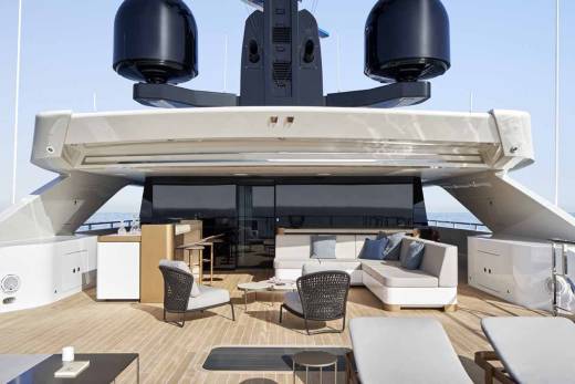Luxurious outdoor lounge areas on a modern yacht offer comfortable seating and elegant design against a backdrop of the open sea.