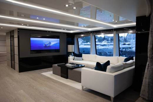 Luxurious yacht salon offers stunning views of the marina through expansive windows.