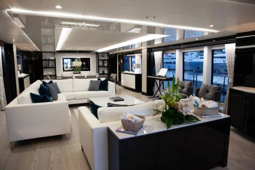 Luxurious yacht interiors offer stunning views of docked vessels through expansive windows.