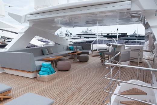 Relax on the spacious deck of this luxurious yacht, complete with comfortable seating and stunning views of other vessels.