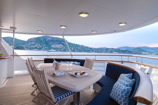 Enjoy a delightful al fresco dining experience on this yacht's deck with stunning coastal views.