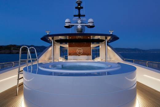 A luxurious yacht's jacuzzi glows under the twilight sky, inviting relaxation on the open sea.