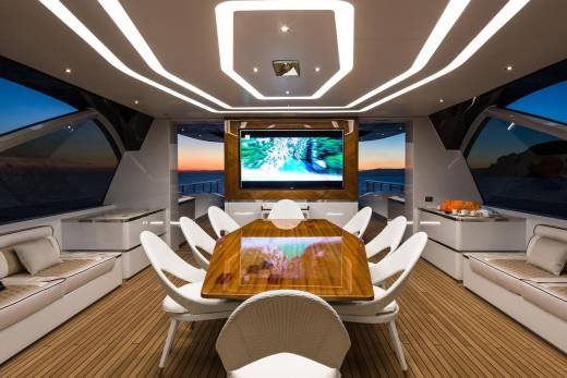 Experience luxurious al fresco dining and entertainment aboard this stunning yacht as the sun sets over the ocean.