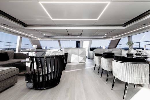 Luxurious yacht interiors feature sleek modern furniture and expansive windows offering breathtaking ocean views.