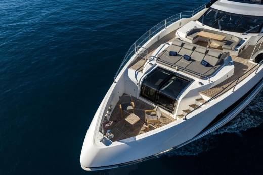 A luxurious yacht glides through the deep blue ocean under a bright sky.