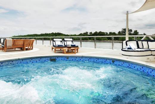 Relax in the bubbling waters of this luxurious yacht's jacuzzi, surrounded by comfortable seating and scenic ocean views.
