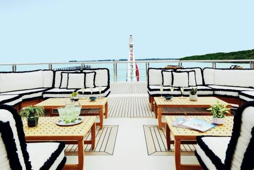 Luxurious outdoor seating on a yacht deck offers a serene spot to enjoy drinks and the ocean breeze.