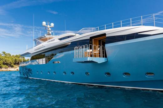 The luxurious yacht "Flying Dragon" glides through the azure waters under a clear blue sky.