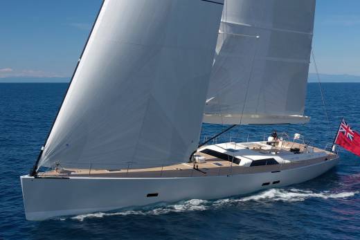 A sleek white sailboat glides through the deep blue ocean under a clear sky.
