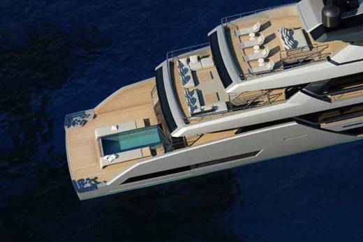 A luxurious yacht with a pristine pool and ample deck space glides through deep blue waters.