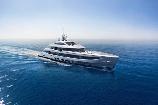 A sleek, modern yacht glides through the deep blue ocean under a clear sky.