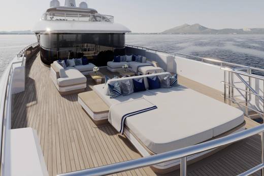 Luxurious white loungers and seating areas adorn the teak deck of this modern yacht, set against a backdrop of calm blue waters and distant hills.