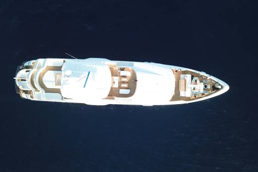 A sleek white yacht glides through the deep blue ocean, its decks inviting relaxation and exploration.
