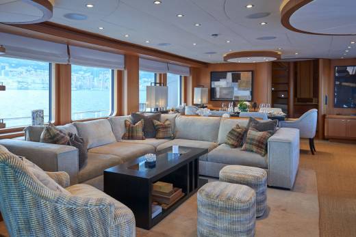 Luxurious yacht interiors offer a serene retreat with expansive windows overlooking the sea and elegant seating arrangements.