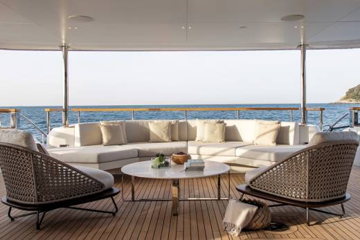 Relax on the spacious deck of this luxury yacht, surrounded by the serene blue ocean and lush green coastline.
