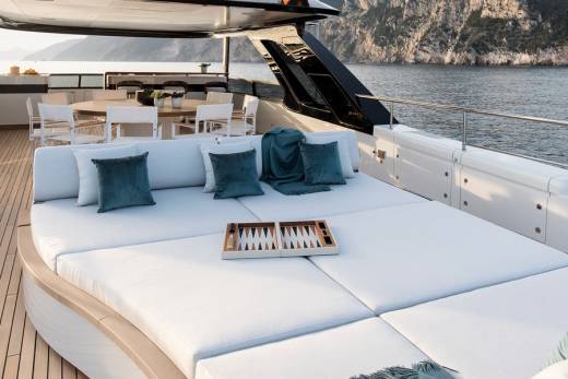 Relax on the spacious deck of a luxury yacht with a game of backgammon and stunning coastal views.
