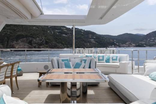 Relax on the spacious deck of this luxurious yacht, surrounded by stunning coastal views and comfortable seating.
