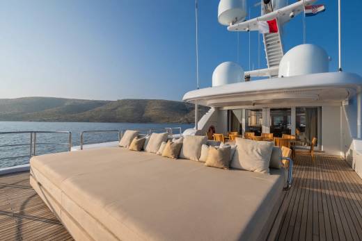 Relax on the expansive sun deck of this luxurious yacht, surrounded by the tranquil blue waters and picturesque coastal landscape.
