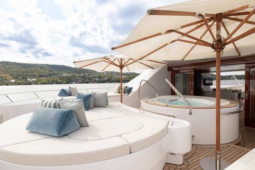 Relax in the hot tub or lounge on the sun deck of this luxurious yacht with a scenic backdrop.