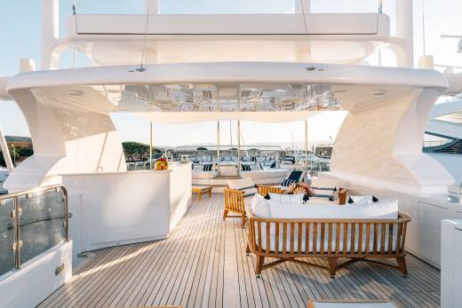 Luxurious outdoor seating and a bar area invite relaxation on the expansive deck of a superyacht.