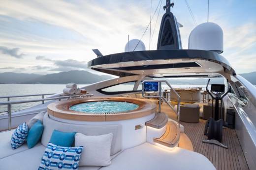 Relax in the bubbling hot tub on the deck of this luxurious yacht with stunning ocean views.