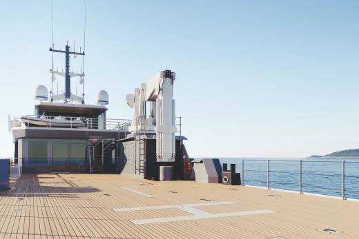 A modern yacht's spacious deck offers a helipad and crane against a backdrop of calm blue seas and a distant island.
